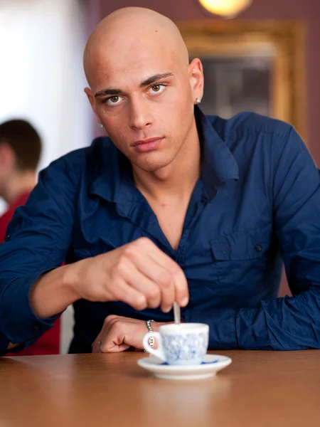 Jonge man drinkt koffie in Cafe — Stockfoto
