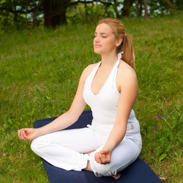 Meditazione in natura - Carina ragazza medita all'aperto su un gr — Foto Stock