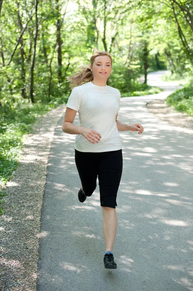 Aantrekkelijke jonge vrouw op een run in de natuur — Stockfoto