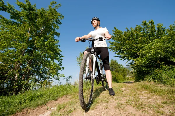 Young girl riding a bike on a field path - offroad — Stock Photo, Image