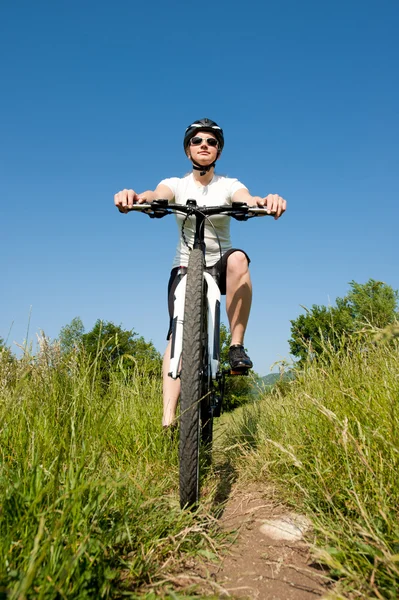 stock image Young girl riding a bike on a field path - offroad