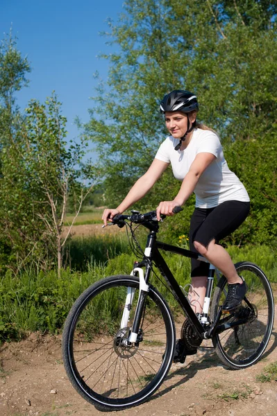 Young girl riding a bike on a field path - offroad — Stock Photo, Image