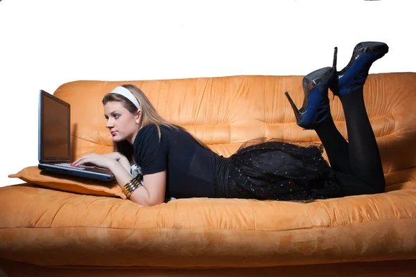 Χαμογελαστό κορίτσι στον καναπέ με φορητό υπολογιστή — Φωτογραφία Αρχείου