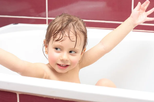 Schattig drie-jaar-oude meisje op zoek uit een bad en glimlachen — Stockfoto