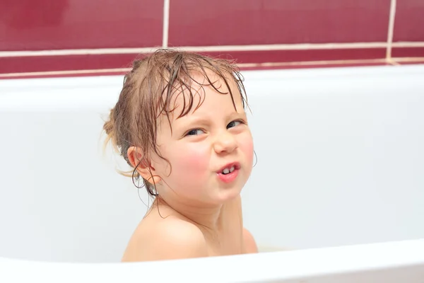 Carina ragazza di tre anni che guarda fuori da un bagno e sorride — Foto Stock