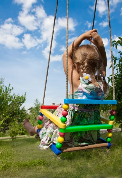 Little girl swinging on a sunny day — Stock Photo, Image