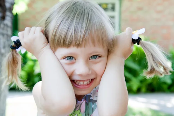 Hermosa pequeña sonrisa con coletas al aire libre . — Foto de Stock