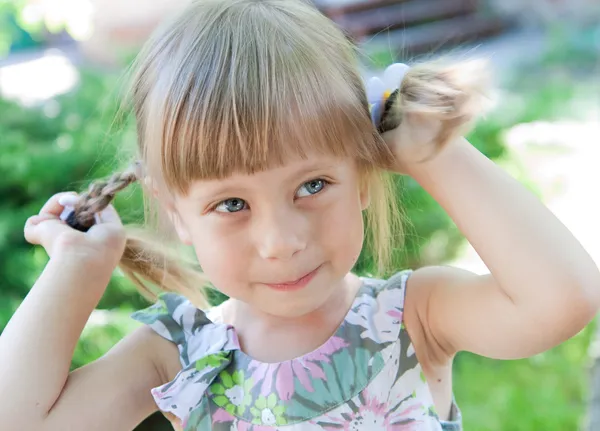 Красивая маленькая девочка с косичками — стоковое фото