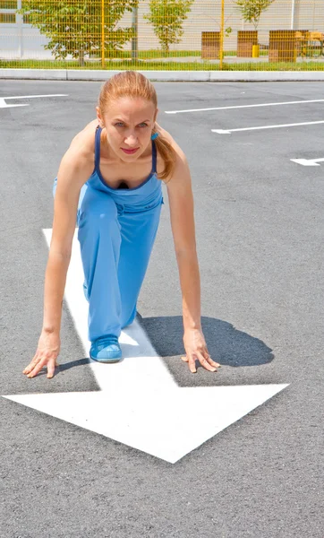 Athletic woman in start position on track — Stock Photo, Image