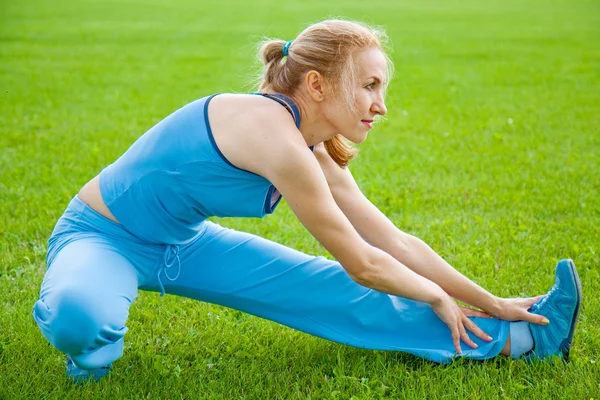 Привлекательная женщина растягивается перед фитнесом и упражнениями — стоковое фото