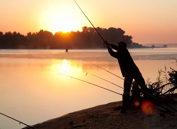 stock image Silhouette of man fishing in a sunset