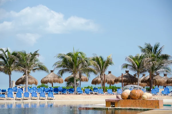 Palapas, pálmák és lawnchairs egy közeli Punta Cancun Resort — Stock Fotó