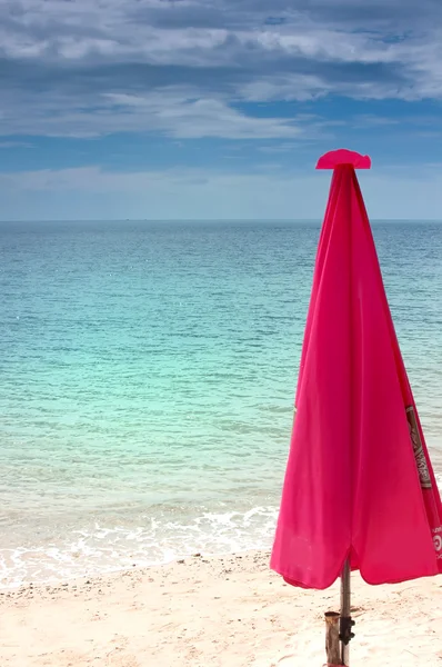 Красный пляжный зонтик — стоковое фото