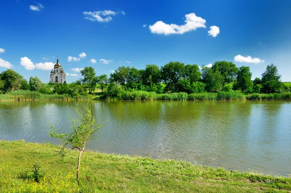 Церковь и озеро под голубым небом — стоковое фото