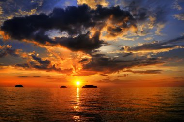 Sea landscape with a sunset and the cloudy sky clipart