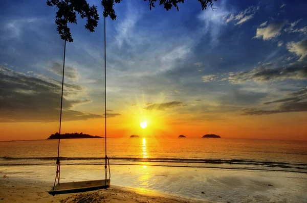 Schaukel am paradiesischen Sonnenuntergang am Strand — Stockfoto