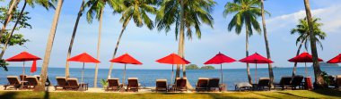 Panorama of perfect tropical beach with red umbrellas clipart