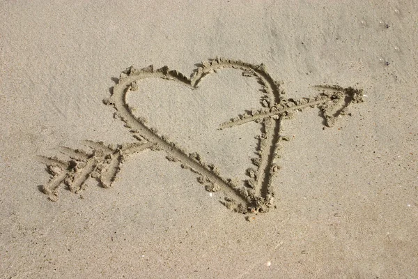 Srdce s šipkou v písku — Stock fotografie