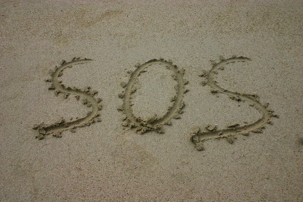 SOS написана на песке — стоковое фото
