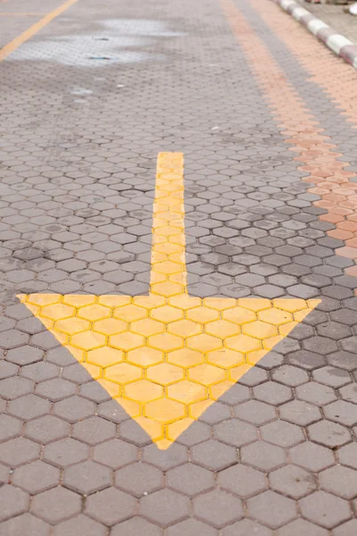 Yellow arrow on the ground — Stock Photo, Image