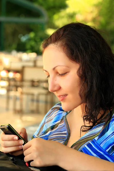 stock image Girl looks at mobile phone