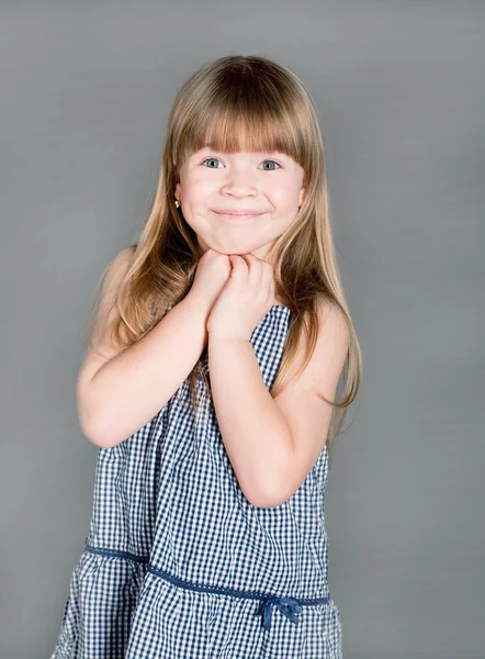 The little girl in a dress smiling with surprise — Stock Photo, Image