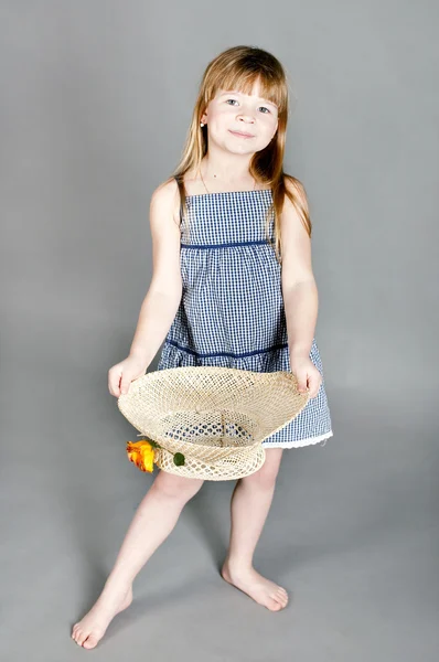Menina em um vestido com um chapéu de palha — Fotografia de Stock