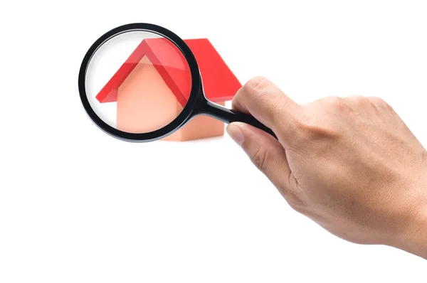 Looking with a magnifying glass on the red roofed house — Stock Photo, Image