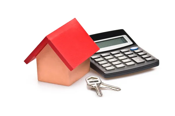 Casa coberta vermelha com calculadora e chaves da casa — Fotografia de Stock