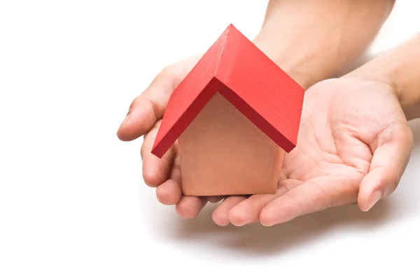 Red roofed house in human hand — Stock Photo, Image