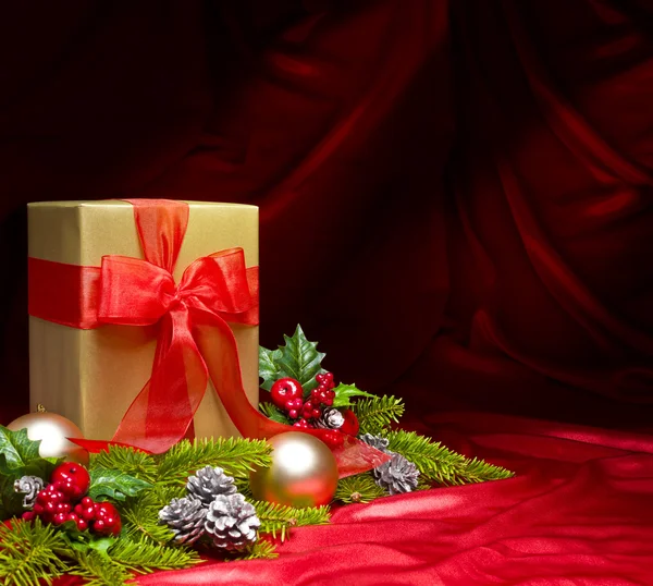Present decorated with red satin and Christmas decoration — Stock Photo, Image