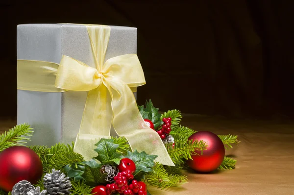 Present decorated with gold satin and Christmas decoration — Stock Photo, Image