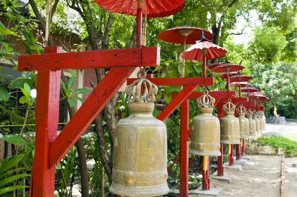 Row of bells in a temple covered by red umbrella — Stock Photo, Image