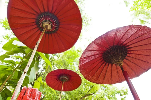 Tres paraguas rojo en un entorno al aire libre —  Fotos de Stock