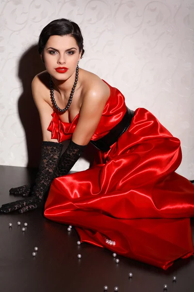 Μια όμορφη νεαρή γυναίκα είναι με κόκκινα ρούχα — Φωτογραφία Αρχείου