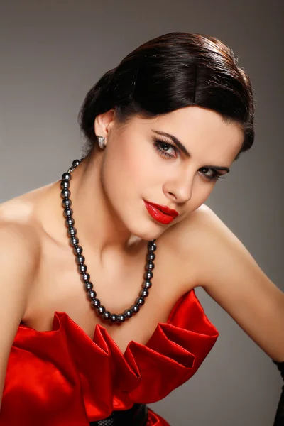 Een mooie jonge vrouw is in rode kleren — Stockfoto