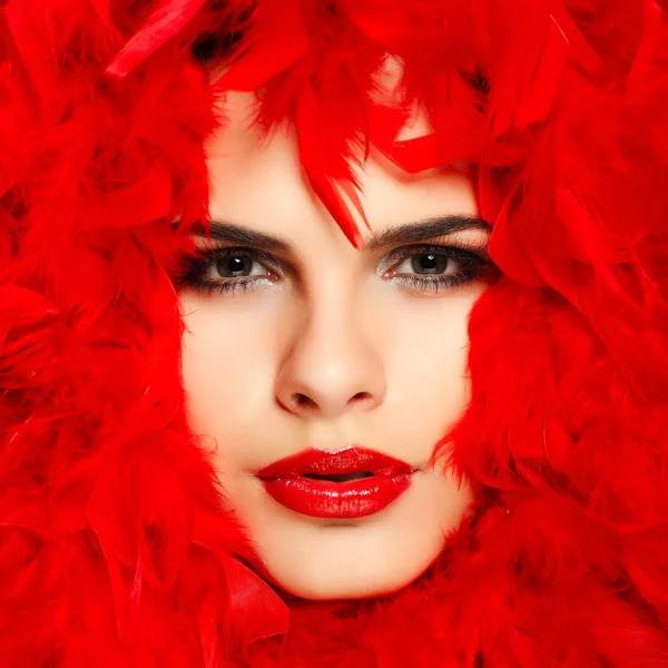 Vackra rödhåriga flicka med röda fjädrar — Stockfoto