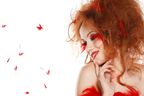 Красивая рыжая девушка с красными перьями — стоковое фото