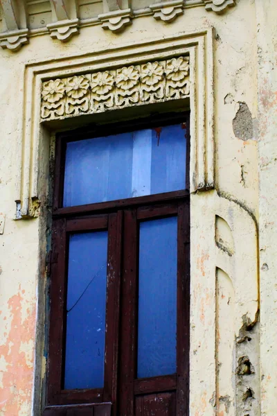A window and a moulding on the wall of the very old house — Stock Photo, Image