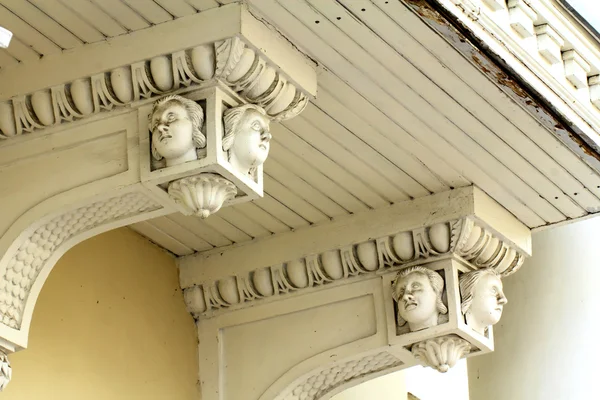An old balcony decorated with beautiful female heads — Stock Photo, Image