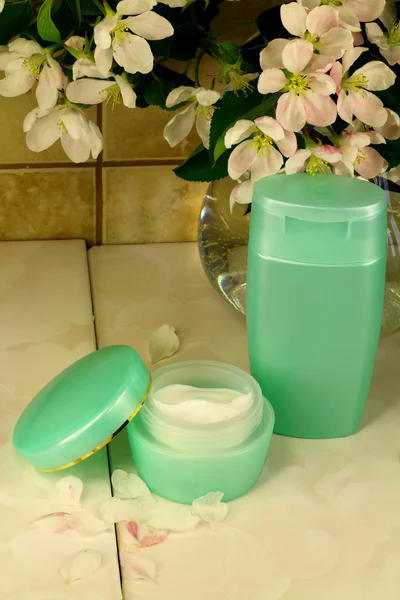 Apple tree flowers, a jar of cream and a shampoo — Stock Photo, Image