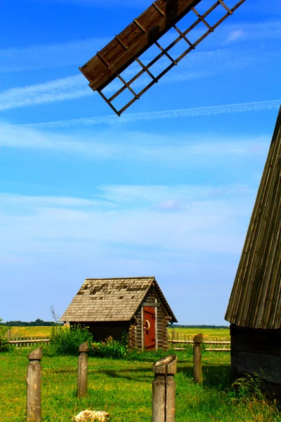 Een windmolen, een klein huis en een blauwe hemel — Stockfoto