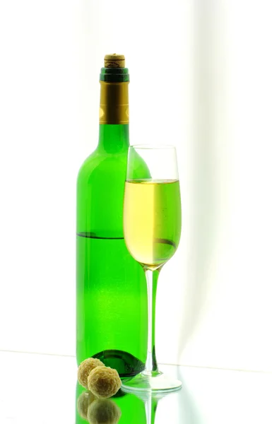 Bir bardağı, bir şişe ve aynada iki şekerler — Stok fotoğraf