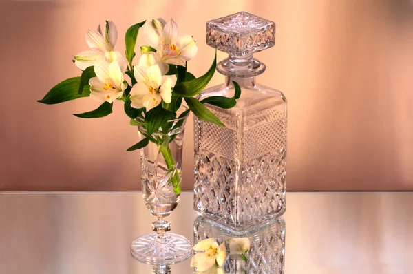 Hermosas flores en el jarrón y la botella de cristal — Foto de Stock