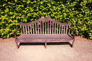 Old, English bench in the garden clipart