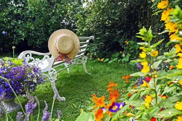 Peacuful summer garden with a hat — Stock Photo, Image
