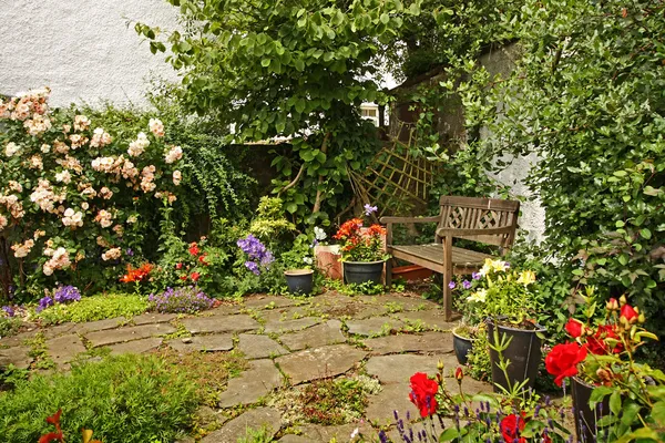 Härlig trädgård med en träbänk — Stockfoto