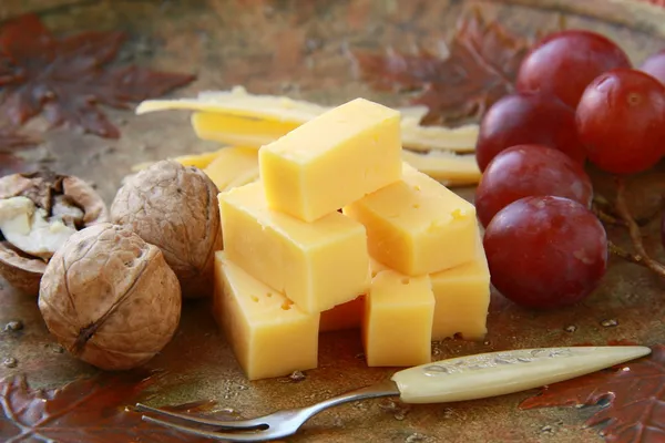 Cheese plate with grapes and walnuts — Stock Photo, Image