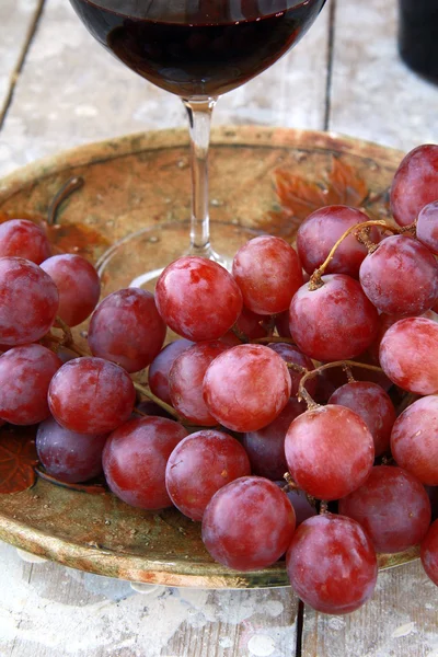 Grandes uvas vermelhas maduras e vinho no fundo natural — Fotografia de Stock