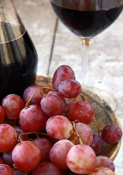 Large red ripe grapes and wine on the natural background